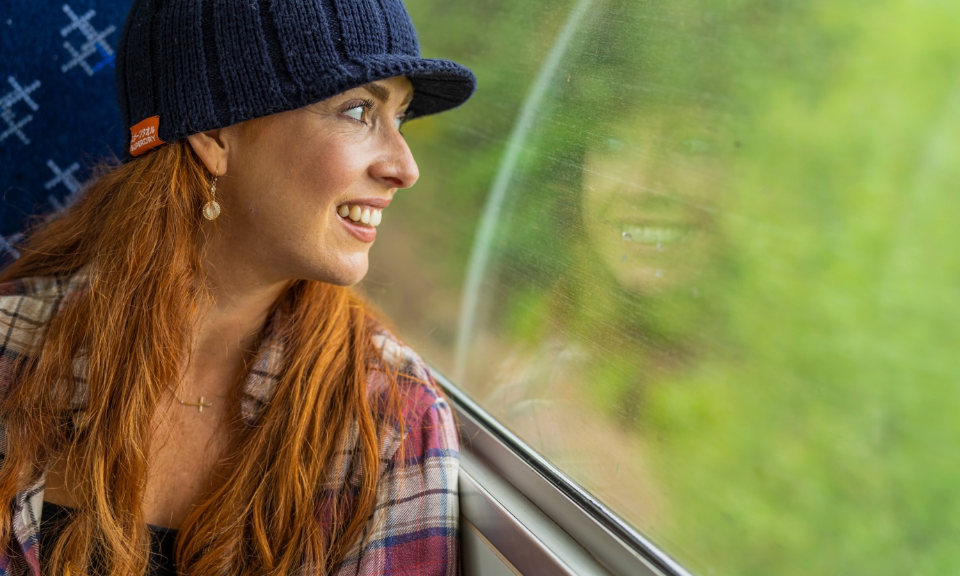 Woman looking out a train window at Bridge of Orchy